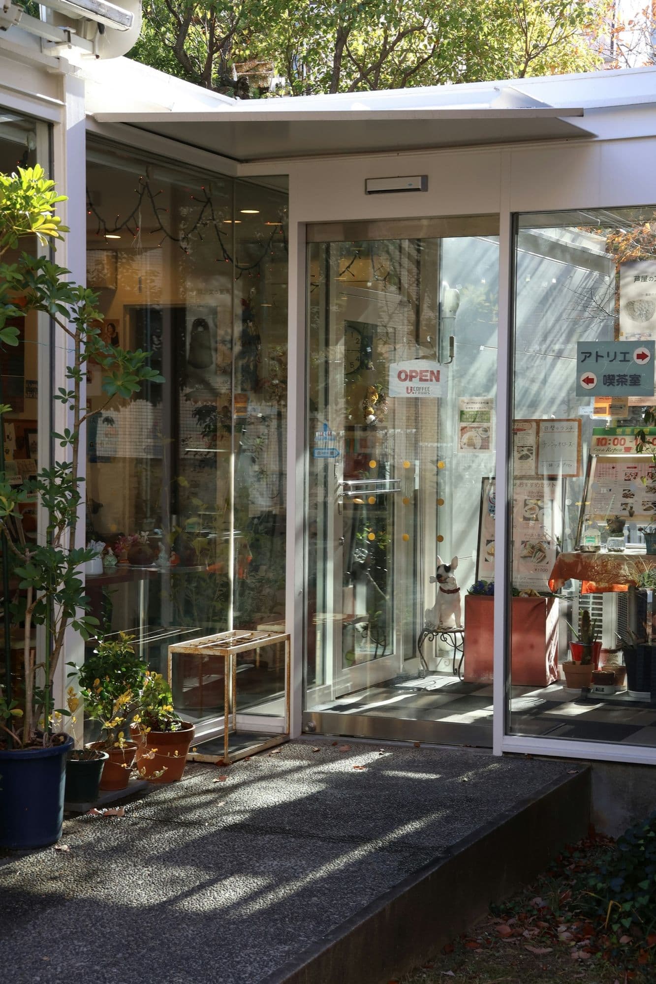 A glazed shop entrance with its sliding leaves opened onto the street